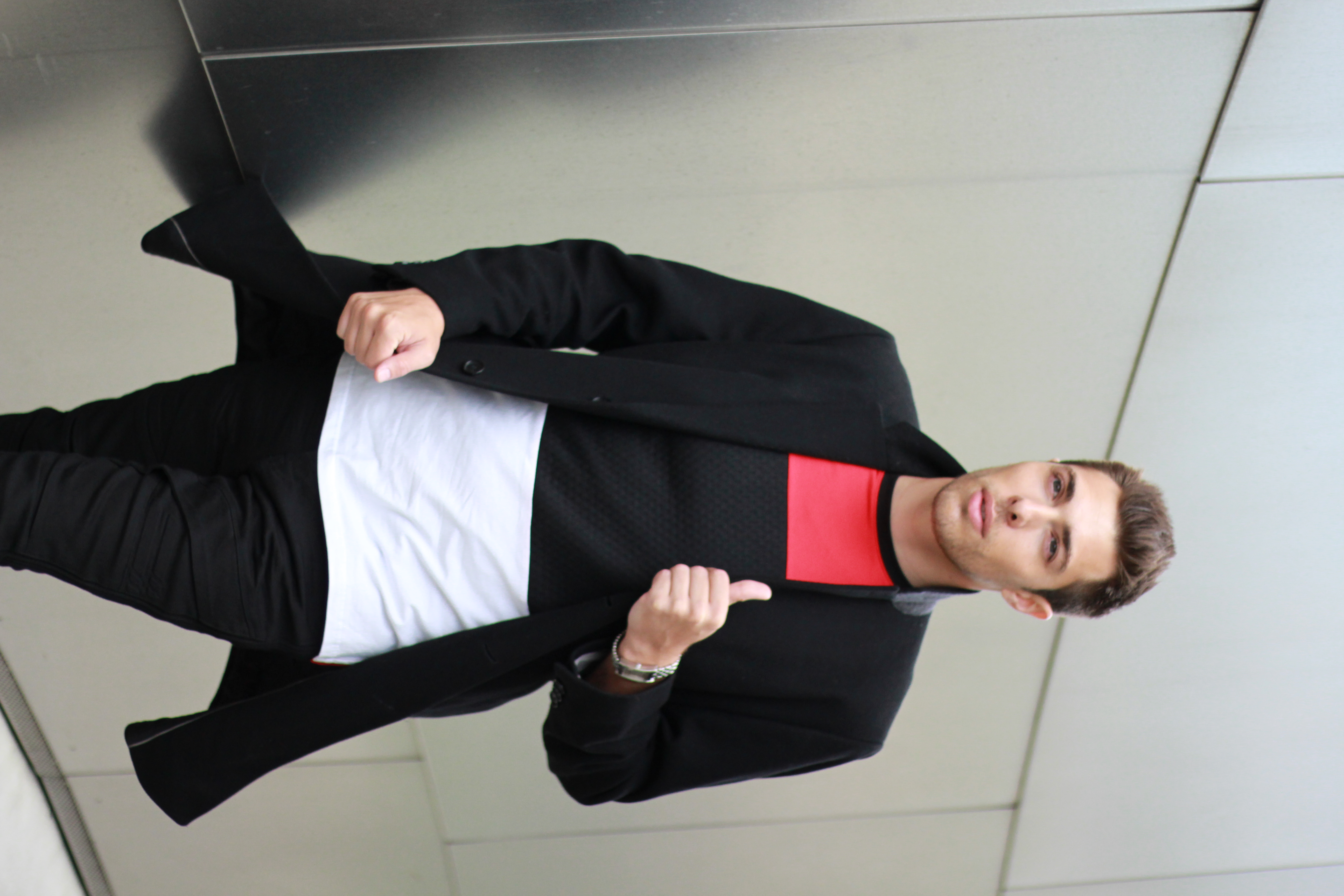 Alex Veach (Alexander Veach) alt-angle color-block coat portrait with red accent.