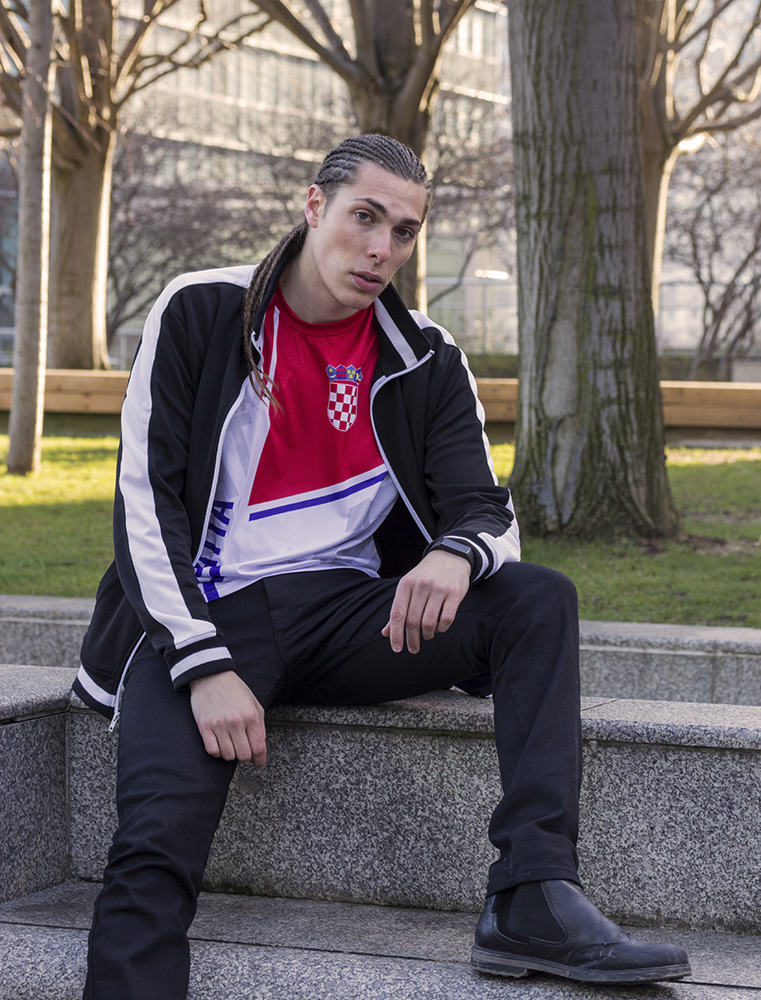Alex Veach (Alexander Veach) Paris editorial, Croatia jersey and track jacket, seated pose.