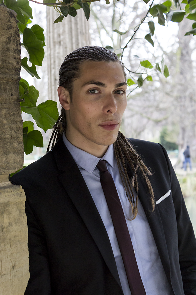 Alex Veach (Alexander Veach) Paris editorial, navy suit and burgundy tie against ivy stone column.
